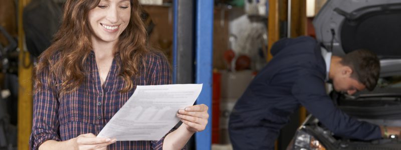 Female Customer In Auto Repair Shop Satisfied With Bill For Car Repair